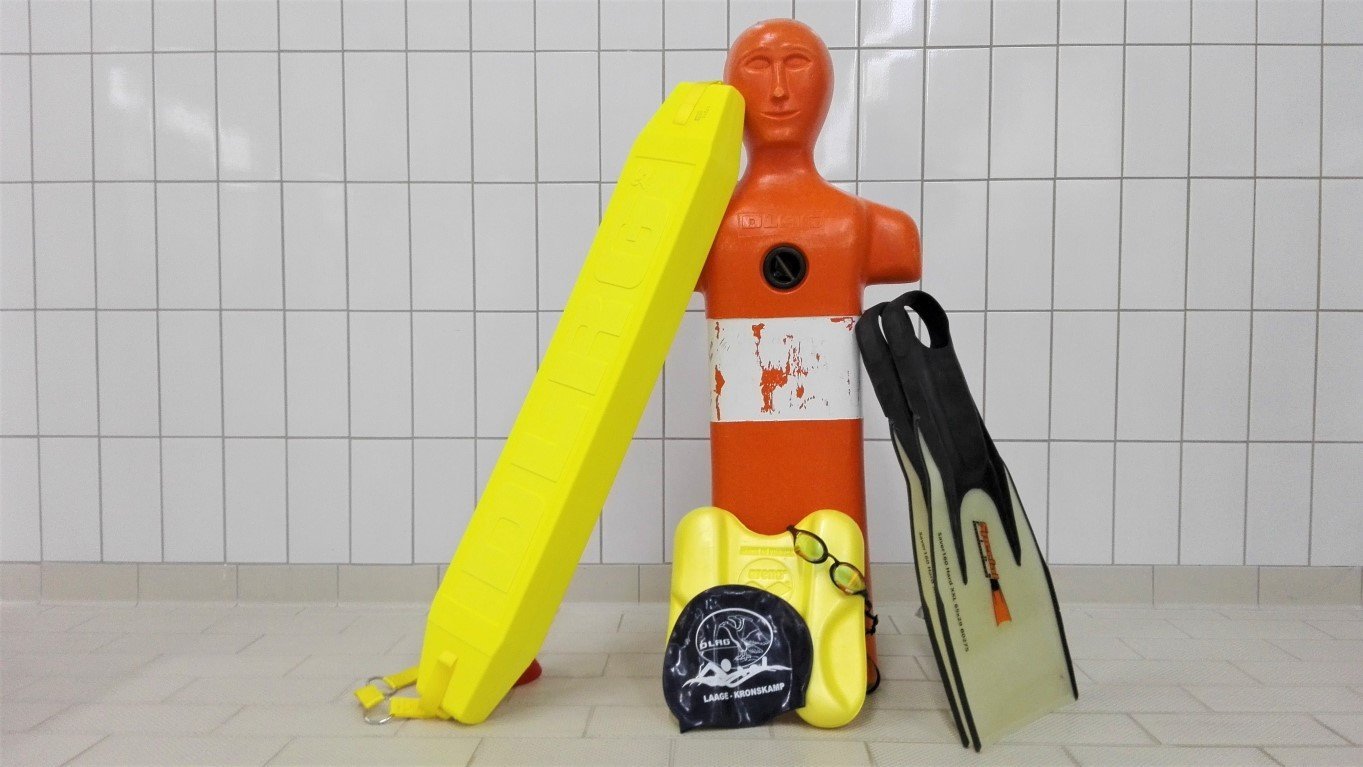 Ausrüstung für Rettungssporttraining: Flossen, Badekappe, Gurtretter, Puppe, Brett